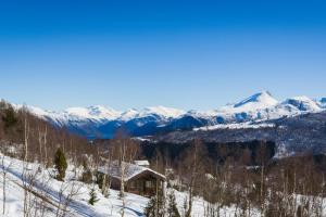 a cabin in the snow with mountains in the background at Fjellro in Stranda