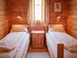two beds in a log cabin with a window at Fjellro in Stranda