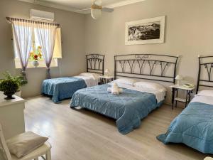 two beds in a room with blue and white at Hotel Odissea in Canneto
