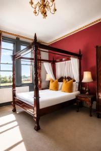 a bedroom with a canopy bed with yellow pillows at The Godwins in Hereford