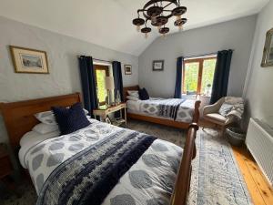 a bedroom with two beds and a chandelier at Salmon Weir Lodge in Cong