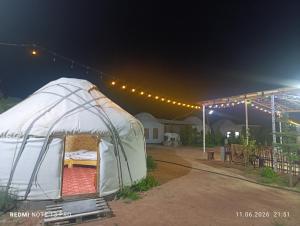 a tent is set up in a yard at night at Айкол Этно Комплекс in Tong