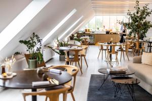 ein Restaurant mit Tischen und Stühlen in einem Raum in der Unterkunft Allinge Badehotel in Allinge