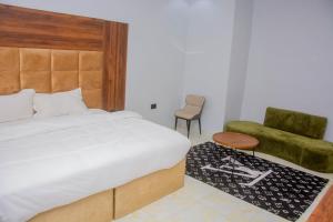 a bedroom with a large bed and a chair at Five Star Meekness Hotel LTD in Oviri