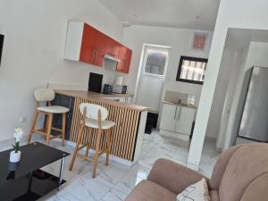 a kitchen and living room with a couch and a table at Maison chaleureuse avec tous confort in Elbeuf