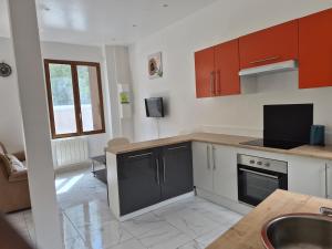 a kitchen with a sink and a stove top oven at Maison chaleureuse avec tous confort in Elbeuf