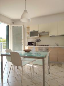 a kitchen with a glass table and chairs in a room at Casa al parco in Romano D'Ezzelino