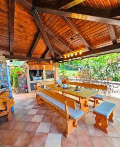 a patio with a table and benches and a kitchen at Apartman Ruza 3 in Poljane