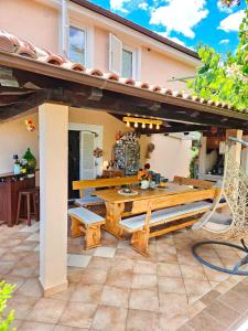 a patio with a wooden table and a bench at Apartman Ruza 3 in Poljane