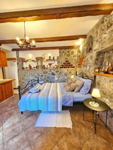 a bedroom with two beds and a stone wall at Apartman Ruza 3 in Poljane