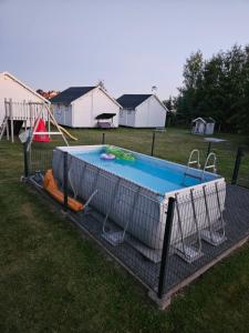 aenced in pool in a yard with a playground at Domki Letniskowe Do-Iwi in Ustronie Morskie