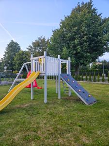a playground with a slide in a park at Domki Letniskowe Do-Iwi in Ustronie Morskie