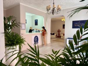 a woman standing at a counter in a house at Hotel Odissea in Canneto