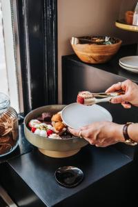 a person holding a plate of food on a table at Hotel Sint Nicolaas in Amsterdam
