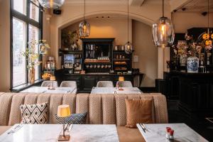 a restaurant with two tables in a room with windows at Hotel Sint Nicolaas in Amsterdam