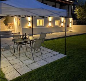 a table and chairs under a tent in a yard at MANDARIN Luxury Suites in Asprovalta