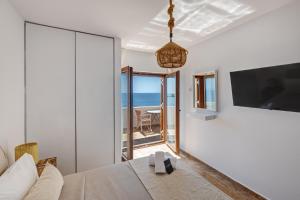 a room with a bed and a view of the ocean at Villa Marelia - Seafront villa with infinity pool in Megas Gialos - Nites