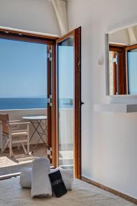 a room with a sliding glass door with a view of the ocean at Villa Marelia - Seafront villa with infinity pool in Megas Gialos - Nites
