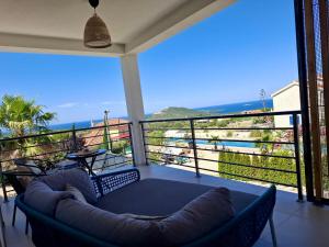 a balcony with a couch and a view of the ocean at Vila Esnella - Private Pool & Panoramic Sea view in Primošten