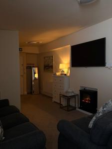 a living room with a fireplace and a flat screen tv at Fahertys bar rooms in Oughterard