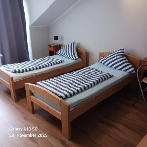 zwei Betten stehen in einem Zimmer mit in der Unterkunft Pension Strohm im Lieth Café in Bad Fallingbostel