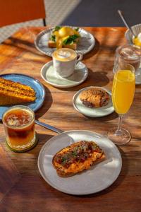 a wooden table with plates of food and glasses of orange juice at Hi Adventure in Florianópolis