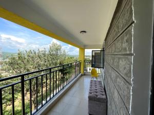 a room with a balcony with a couch and a television at Bay Loft 1 Br Netflix Lake Views, Starlink in Homa Bay