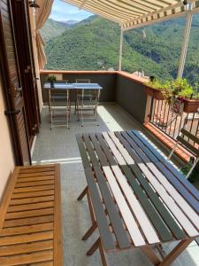 a wooden bench sitting on a balcony with a table at La terrazza nel borgo in Tortora