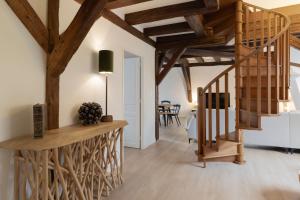 a staircase in a living room with wooden beams at Le JOLIE DUPLEX in Colmar