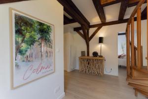 a living room with a large painting on the wall at Le JOLIE DUPLEX in Colmar