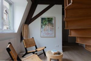 a living room with two chairs and a table at Le JOLIE DUPLEX in Colmar