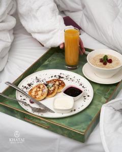a tray with a plate of breakfast food and a drink at Khatai Center Hotel in Baku +26 photos