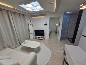 a living room with a white couch and a tv at 화곡역 에스엠파크빌 in Seoul