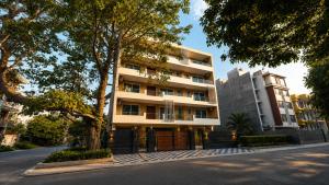 a building on a street next to a tree at CORPORATE STAYS-Golf Course Road in Gurgaon