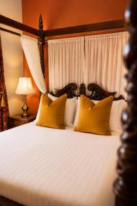 a bedroom with a bed with two yellow pillows at The Godwins in Hereford +44 photos