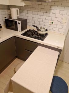 a kitchen with a stove top oven next to a microwave at 화곡역 에스엠파크빌 in Seoul