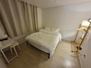 a small bedroom with a bed and a table at 화곡역 에스엠파크빌 in Seoul