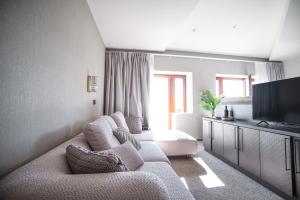 a living room with a couch and a flat screen tv at Boutique Hotel Solterra - Crikvenica in Crikvenica