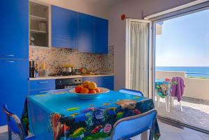 a kitchen with a table with a bowl of fruit on it at Residence Mare Blu in Capo dʼOrlando