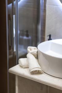 a bathroom with a sink and towels on a counter at Breeze Apartments Megara - Linea in Megara
