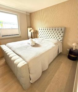 a bed with a white stuffed animal on top of it at Sassnitz - Modernisiert 2026 - Outdoor Teich, Spa-Sauna, Fitness, Kamin - FeWo Fontane in Sassnitz