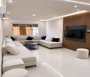 a living room with a couch and a tv at Al Hoceima Luxury Residence Amina 3 in Al Hoceïma