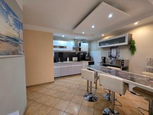 a large kitchen with white cabinets and a counter at SWINEMÜNDE Fewo Speckmann in Świnoujście +15 photos