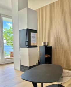 a dining room with a table and a refrigerator at Sassnitz - Modernisiert 2026 - Outdoor Teich, Spa-Sauna, Fitness, Kamin - FeWo Fontane in Sassnitz