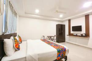 a bedroom with a bed and a flat screen tv at FabHotel Blue Dawn Gachibowli in Gachibowli