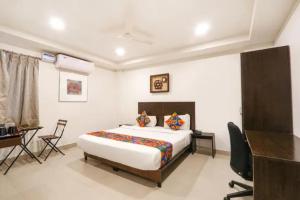 a bedroom with a bed and a desk and a desk at FabHotel Blue Dawn Gachibowli in Gachibowli +39 photos
