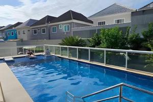 a large blue swimming pool in front of some houses at Suite Incrível Sonhos e Praia in Rio de Janeiro