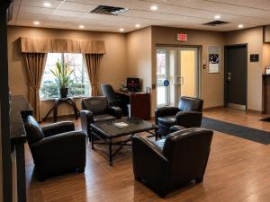 a waiting room with chairs and a table and a waiting room at Ramada by Wyndham Trenton in Trenton