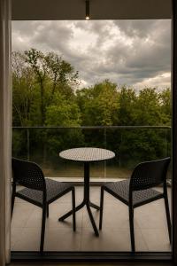two chairs and a table on a balcony with a table and chairs at Grand Hotel President in Baile Felix