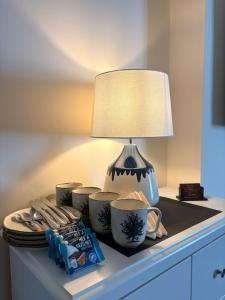 a table with a lamp and plates and cups on it at Fahertys bar rooms in Oughterard